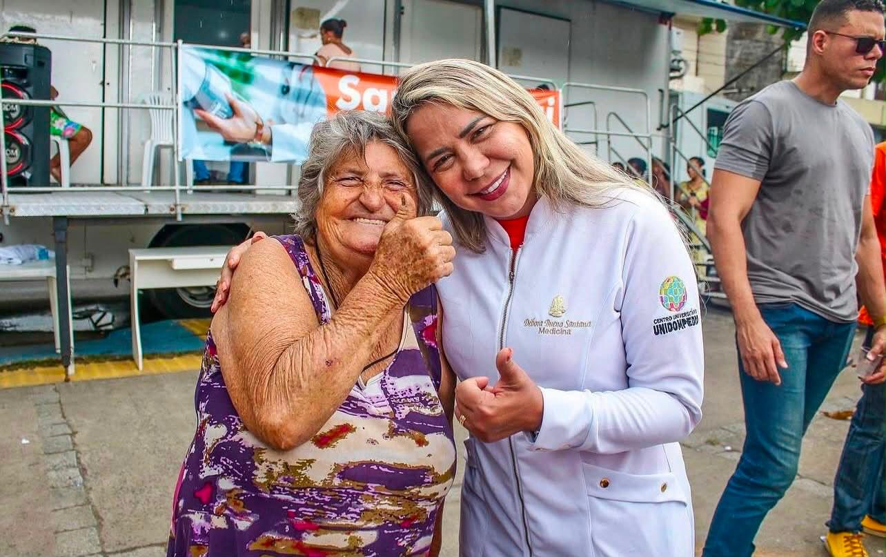 Débora Santana em uma ação de saúde ao lado de uma moradora
